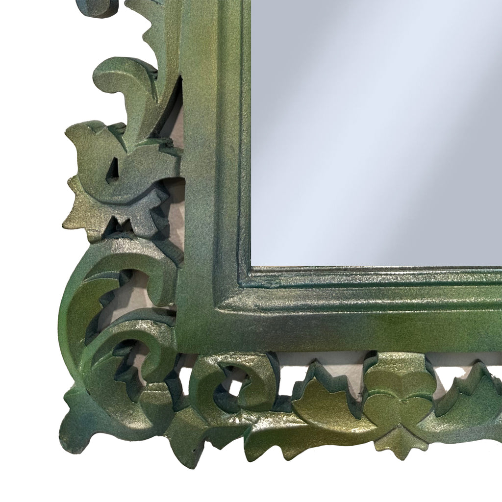 Corner detail of carved green mirror on white background