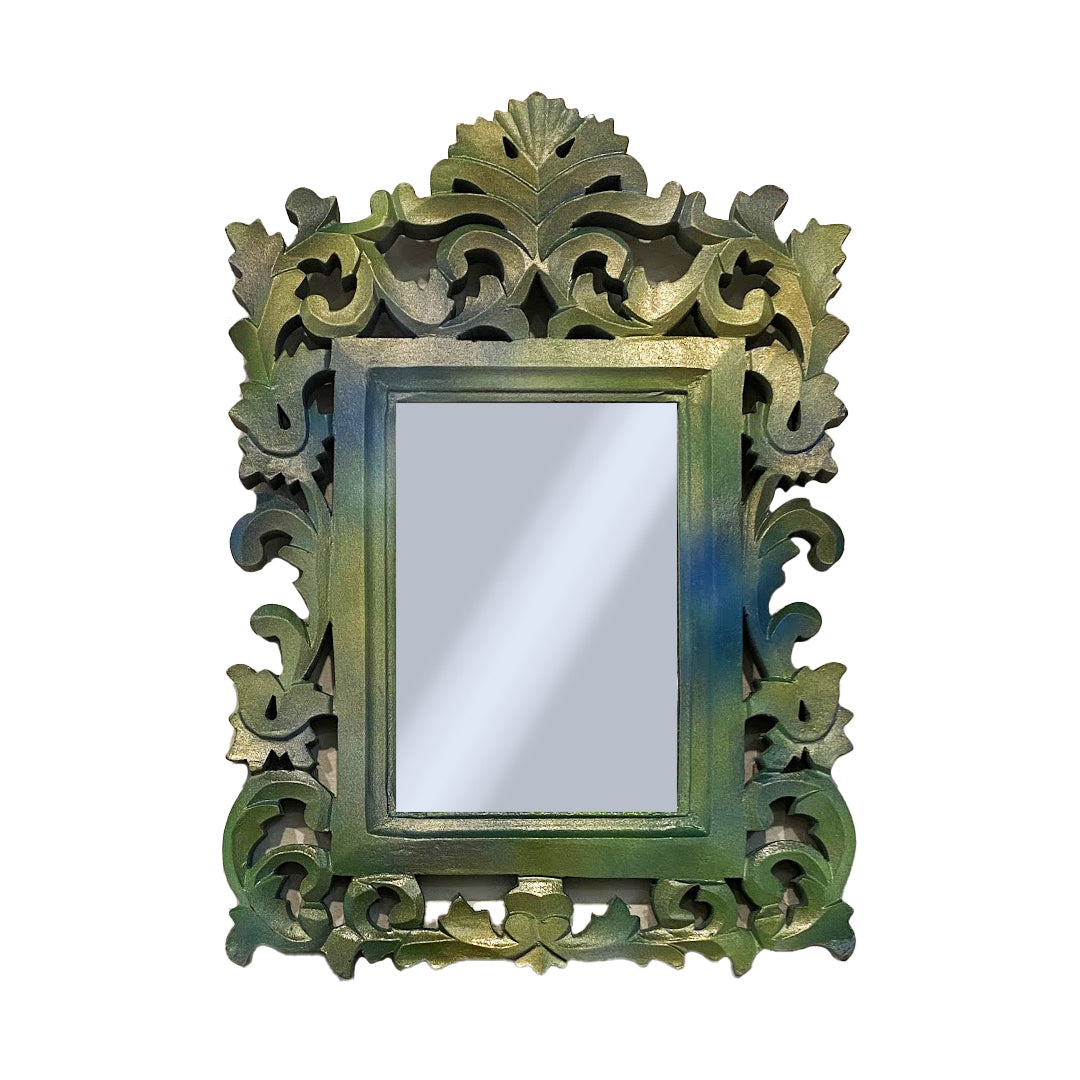 Decorative carved mirror with intricate green frame on a white background
